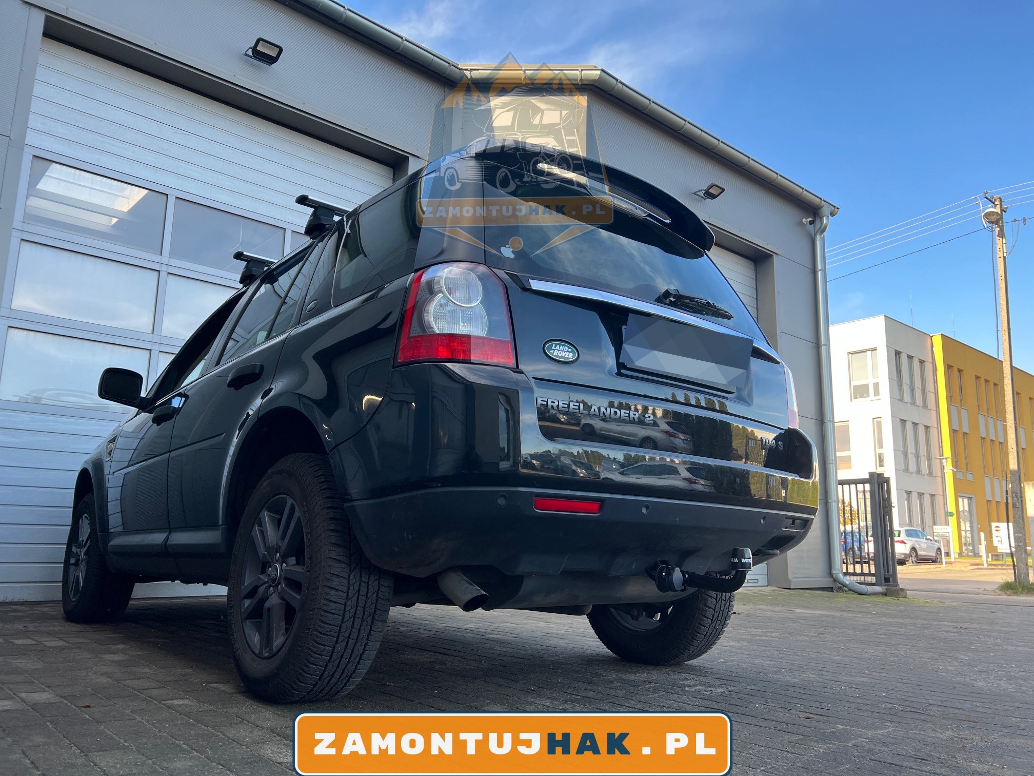 Zdjęcie samochodu Land Rover Freelander z zamontowanym stałym hakiem holowniczym Westfalia f20, zdjęcie zrobiono z tyłu, z lewej strony samochodu na tle serwisu zamontujhak.pl 